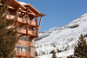 a ski lodge with a snow covered mountain in the background at Le Souleil'Or in Les Deux Alpes