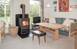 a living room with a couch and a wood stove at 2 Bedroom Nice Home In Hejls in Hejls