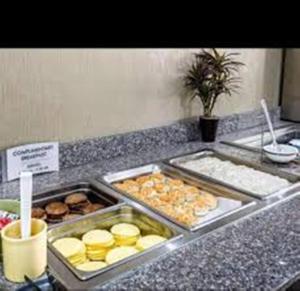 a counter with several trays of food on a counter at SureStay Plus Hotel by Best Western Blue Springs in Blue Springs