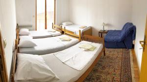a room with four beds and a blue chair at SARAJEVO-ADI APARTMENTS II in Sarajevo