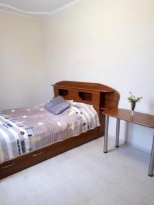 1 dormitorio con 1 cama y 1 mesa en Сьоме небо - The Seventh Heaven, en Doroshuv Velikiy