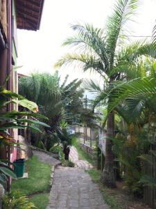 um caminho com palmeiras e um edifício em VELINN Pousada Catamarã Brasil em Ilhabela