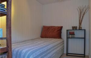 małą sypialnię z łóżkiem z pomarańczową poduszką w obiekcie One-Bedroom Holiday Home In Tisvildeleje w mieście Tisvilde +5 zdjęć