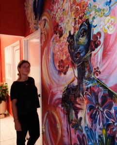 ポパヤンにあるLienzo Hostel and Mural Art Museumの女性の絵画の横に立つ女性 +28枚の写真