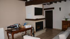 a living room with a fireplace and a television at Castillo de Portilla Casa Rural in Portilla