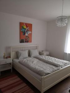 1 cama en un dormitorio con una pintura en la pared en Vadóka ház, en Őriszentpéter