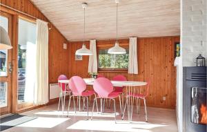 Bjerregårdにある3 Bedroom Cozy Home In Hvide Sandeのピンクの椅子とテーブル付きのダイニングルーム