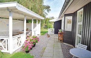 a backyard patio with a white pergola and flowers at Amazing Home In Vejby With 3 Bedrooms And Wifi in Vejby