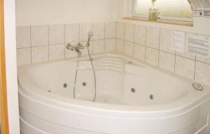 a bath tub with a shower in a bathroom at Holiday Home Strandparken in Otterup