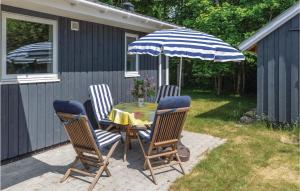 a table with chairs and an umbrella on a patio at Three-Bedroom Holiday Home In Slagelse in Slagelse +12 photos