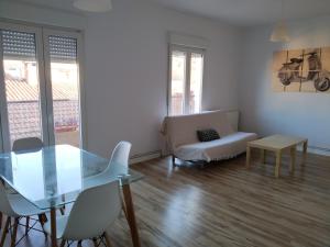 Apartamento Mudejar في تيرويل: غرفة معيشة مع طاولة زجاجية وأريكة
