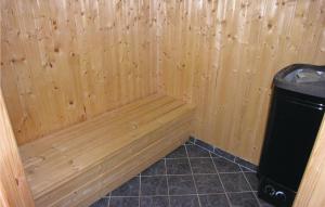 a wooden sauna with a bench next to a trashcan at Holiday Home Strandparken in Otterup