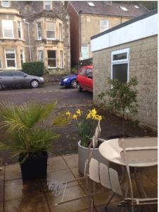 a patio with a table and chairs and plants at Alexandra Annexe in Bath