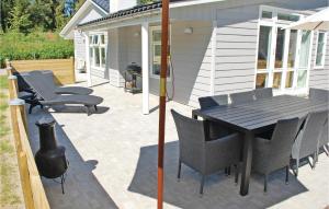 a patio with a black table and chairs at Four-Bedroom Holiday Home Ebeltoft With A Fireplace 04 in Øksenmølle