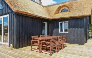 eine Holzterrasse mit einem Tisch und Stühlen auf einem Haus in der Unterkunft Three-Bedroom Holiday Home In Knebel in Knebel + 25 Fotos