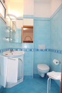 ein blaues Bad mit einem Waschbecken und einem WC in der Unterkunft Hotel Gran Venere Beach 3 Superior in Bibione