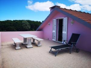 a pink house with a picnic table and a bench at Villa da Silva in Madalena