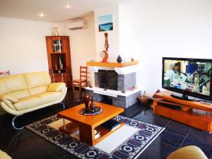 a living room with a couch and a television at Villa da Silva in Madalena