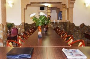 a long table with vases of flowers on it at Hotel Orizont Suceava in Suceava