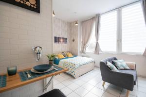 a living room with a bed and a table at Appart'Confort - Le Scandi-Cosy in Saint-Brieuc