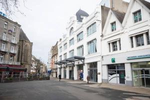 an empty street in a city with white buildings at Appart'Confort - Le Scandi-Cosy in Saint-Brieuc