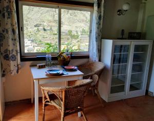 eine Küche mit einem Tisch und Stühlen sowie einem Fenster in der Unterkunft Finca La Ladera in Valle Gran Rey