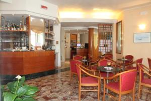 um restaurante com mesas e cadeiras e um bar em Hotel Gran Venere Beach 3 Superior em Bibione
