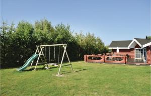 a swing set in a yard with a house at Holiday Home Enebærvænget in Humble