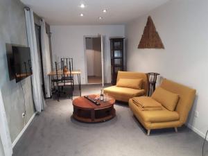 ein Wohnzimmer mit 2 Stühlen und einem Couchtisch in der Unterkunft Naova Cosy Studio in Kaysersberg