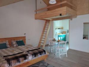 a bedroom with a bed and a table with a ladder at Апартаменти Декорум in Skhidnitsa