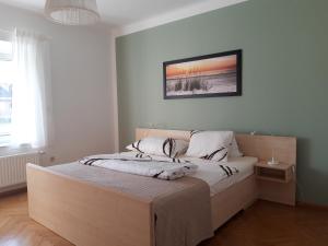 ein Schlafzimmer mit einem großen Bett mit einer weißen Tagesdecke in der Unterkunft Apartment and more in Klagenfurt am Wörthersee