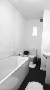 La salle de bains blanche est pourvue d'une baignoire et de toilettes. dans l'établissement Beach Road, à Margate