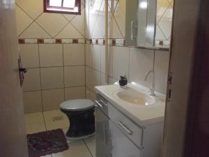 a bathroom with a sink and a toilet at Itaimbezinho Hostel Santa Catarina in Praia Grande
