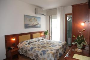 a bedroom with a bed and a table at Hotel Gran Venere Beach 3 Superior in Bibione