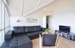 sala de estar con sofá de cuero negro y TV en Awesome Home In Silkeborg With House Sea View, en Silkeborg