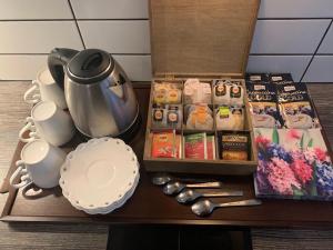 a wooden table with a tea pot and tea packets at Mirellas Apartment in Svalöv