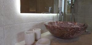 a bathroom with a bowl and two cups on a counter at Borgo di Santa Barbara in Santa Domenica