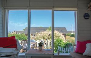 a screened in porch with a table and a window at Stunning Home In Sjlund With Kitchen in Sjølund