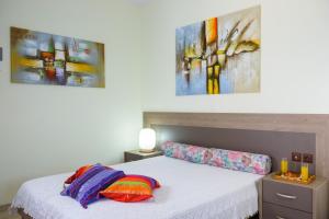 1 dormitorio con 1 cama con 2 cuadros en la pared en BEACH HOUSE en Milatos