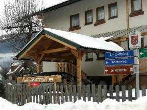 un edificio con un gazebo in legno nella neve di Angi's Apartment a Sankt Lorenzen ob Murau Altre 6 foto