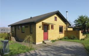 アリンエにあるNice Home In Allinge With Kitchenの赤い扉の小さな黄色レンガ造りの家