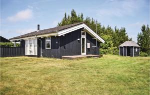 a black and white house with a grass yard at 3 Bedroom Gorgeous Home In Ejstrupholm in Krejbjerg