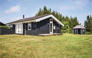 a black and white house with a grass yard at Beautiful Home In Ejstrupholm With 3 Bedrooms And Wifi in Krejbjerg