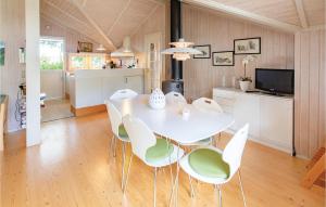 a kitchen and dining room with a white table and chairs at Nice Home In Rude With Kitchen in Rude