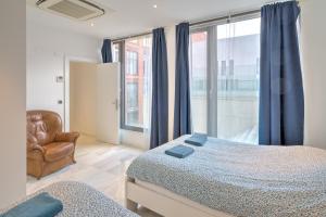 a bedroom with a bed and a chair and a window at Marble Lodge Apartments in the Center of Antwerp in Antwerp