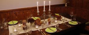 - une table avec des bougies et des serviettes vertes dans l'établissement The Moosbach Garden, à Nordrach