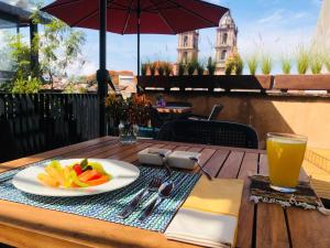 a table with a plate of food and a glass of orange juice at Múbú Hotel Boutique in Valle de Bravo