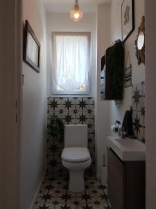 a bathroom with a toilet and a window and a sink at Loretxea in Sare