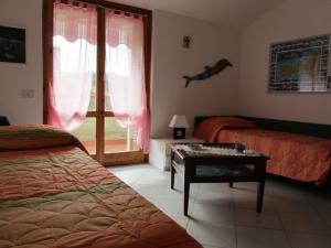 una camera con letto, tavolo e finestra di Albariba a Porto Azzurro