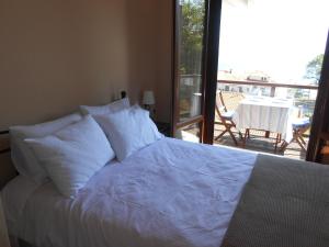 łóżko z białą pościelą i poduszkami w sypialni w obiekcie AUTUMN TO SUMMER w mieście Agios Ioannis Pelio